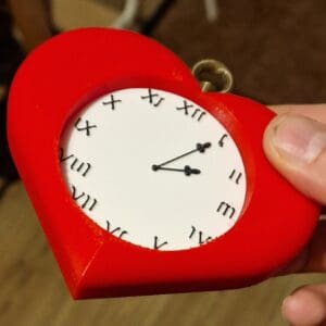 Picture showing a red heart with inset white / black clock. The clock hands read five minutes past two.
